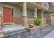 Inviting front porch with stone accents, columns, and a vibrant red front door at 22911 E Euclid Cir, Aurora, CO 80016
