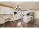 Bright kitchen with white cabinetry, stainless steel appliances, a central island, and stylish light fixtures at 22911 E Euclid Cir, Aurora, CO 80016