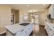 Spacious kitchen island with a gas cooktop and white cabinets, offering ample space for cooking and entertaining at 22911 E Euclid Cir, Aurora, CO 80016