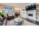 Cozy living room featuring hardwood floors, a fireplace, and a large window for natural light at 22911 E Euclid Cir, Aurora, CO 80016