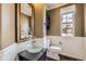 Charming powder room features a vessel sink, decorative mirror, and wainscoting at 22911 E Euclid Cir, Aurora, CO 80016