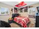This bedroom features posters and sports-themed decor, and a large window with a view at 2792 S Stuart St, Denver, CO 80236