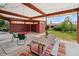 Covered patio with seating, dining table, and access to the backyard and shed at 2792 S Stuart St, Denver, CO 80236