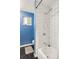 Bathroom featuring a shower over tub with white subway tile and blue accent wall at 4647 W Dakota Ave, Denver, CO 80219