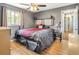 Cozy bedroom with a ceiling fan, wood-look flooring, and a decorative headboard at 4647 W Dakota Ave, Denver, CO 80219
