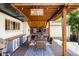 Inviting covered patio with custom woodwork, dining area, and outdoor seating for relaxing and entertaining at 4647 W Dakota Ave, Denver, CO 80219