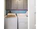 Convenient laundry room featuring a washer and dryer with storage cabinets above at 4647 W Dakota Ave, Denver, CO 80219