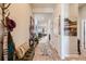 Inviting hallway featuring light wood floors, neutral walls, and stylish décor leading into the home's living spaces at 21985 E Bailey Pl, Aurora, CO 80016