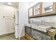 Bathroom with double sinks, modern vanity with metal base and laundry area at 2000 Arapahoe St # 305, Denver, CO 80205