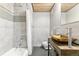 Modern bathroom featuring unique gold sink, stone tile walls, and bathtub with shower at 2000 Arapahoe St # 305, Denver, CO 80205