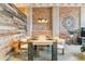 Elegant dining room with rustic wood wall, exposed brick, and modern lighting creating a unique ambiance at 2000 Arapahoe St # 305, Denver, CO 80205