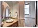 Elegant powder room with a decorative mirror, vessel sink, and marble accents, creating a luxurious feel at 1030 S Adams St, Denver, CO 80209