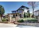 Stunning stone exterior showcasing lush landscaping, gated entry, and unique architectural details on a sunny day at 1030 S Adams St, Denver, CO 80209