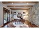 Stylish office features wooden beams, exposed stone wall, hardwood floors, and custom built-ins for a sophisticated workspace at 1030 S Adams St, Denver, CO 80209