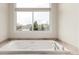 Elegant bathroom with a large bathtub and window offering scenic views, perfect for relaxation and enjoying the peaceful surroundings at 6391 S Malaya St, Centennial, CO 80016