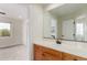 Bathroom featuring vanity with sink, large mirror, and adjacent bedroom at 6391 S Malaya St, Centennial, CO 80016