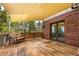 Outdoor deck features a partial shade cover, wooden floors, and brick accents for cozy outdoor enjoyment at 6391 S Malaya St, Centennial, CO 80016
