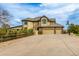 Exterior elevation of the rear of home showcasing an expansive three car garage and fenced yard at 6391 S Malaya St, Centennial, CO 80016