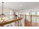 Upper level hallway featuring a curved wood railing, hardwood floors and a bedroom view at 6391 S Malaya St, Centennial, CO 80016
