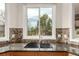 A kitchen sink with beautiful mosaic backsplash tiles and lovely windows above at 6391 S Malaya St, Centennial, CO 80016