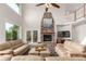 Spacious living room featuring a floor-to-ceiling stone fireplace, vaulted ceilings, and large windows at 6391 S Malaya St, Centennial, CO 80016