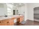 Bathroom featuring dual sinks, large mirror and vanity, and wood floors at 6391 S Malaya St, Centennial, CO 80016