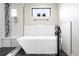Luxurious bathroom features a freestanding tub, stylish fixtures, and mosaic tile at 2231 W 36Th Ave, Denver, CO 80211