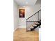 Modern staircase with wood treads and a black metal railing, accented by a vibrant artwork and hardwood flooring at 2231 W 36Th Ave, Denver, CO 80211