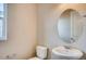 Bathroom with a toilet, oval mirror, white sink, brushed nickel faucet, and towel bar at 13374 Blue Amber Ct, Parker, CO 80134