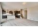 Open-concept living room with light wood flooring and a view into the modern kitchen at 13374 Blue Amber Ct, Parker, CO 80134