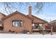 Snow-covered backyard with deck, trees, and a brown house at 7900 E Dartmouth Ave # 76, Denver, CO 80231