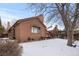 Back of house showing backyard, deck, and trees in winter at 7900 E Dartmouth Ave # 76, Denver, CO 80231