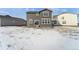 Snowy backyard view of house with distant homes visible at 996 Kolz Pt, Elizabeth, CO 80107