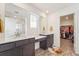Bathroom with dual sinks, walk-in shower, and vanity adjacent to a walk-in closet at 996 Kolz Pt, Elizabeth, CO 80107