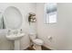 Clean half bathroom with a pedestal sink, toilet, and window at 996 Kolz Pt, Elizabeth, CO 80107