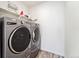Laundry room featuring gray, front-loading washer and dryer and white shelving for storage at 996 Kolz Pt, Elizabeth, CO 80107