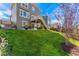 A lush green backyard features a patio, well-maintained lawn, and a young tree with vibrant red leaves at 1043 High Point Trl, Elizabeth, CO 80107