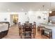 Bright dining area with wood table, bar seating, and access to the living room and staircase at 1043 High Point Trl, Elizabeth, CO 80107
