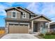 Inviting two-story home displaying a covered porch, two-car garage, and nicely landscaped front yard at 1043 High Point Trl, Elizabeth, CO 80107