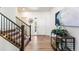 Bright foyer featuring hardwood floors, staircase, and stylish console table with decor at 1043 High Point Trl, Elizabeth, CO 80107
