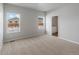 Sunlit bedroom with neutral carpet and an adjacent bathroom for convenience at 2184 Alyssa St, Fort Lupton, CO 80621