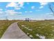 Curving community walking path that leads to a playground and grassy fields at 2184 Alyssa St, Fort Lupton, CO 80621