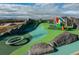 Adventure playground with a long slide, climbing equipment, and large boulders on astroturf at 1702 W 66Th Ave, Denver, CO 80221
