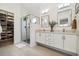 Bright bathroom with double vanity, walk-in shower and walk-in closet at 1702 W 66Th Ave, Denver, CO 80221