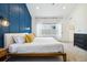 Bright bedroom featuring a large bed, stylish blue accent wall, and lots of natural light from the large window at 1702 W 66Th Ave, Denver, CO 80221