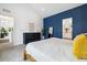 Primary bedroom featuring paneled accent wall and open doorway to the ensuite bathroom at 1702 W 66Th Ave, Denver, CO 80221