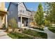 Beautiful home featuring a covered front porch, balcony, landscaped front yard, and walkway at 1702 W 66Th Ave, Denver, CO 80221