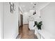Hallway with modern lighting, a white storage bench, and stainless steel appliances at 1702 W 66Th Ave, Denver, CO 80221