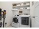 Laundry room with modern washer and dryer and built in shelves at 1702 W 66Th Ave, Denver, CO 80221