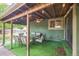 Covered patio features ample seating with a table, artificial grass and exposed ceiling beams at 10462 Hoyt St, Westminster, CO 80021